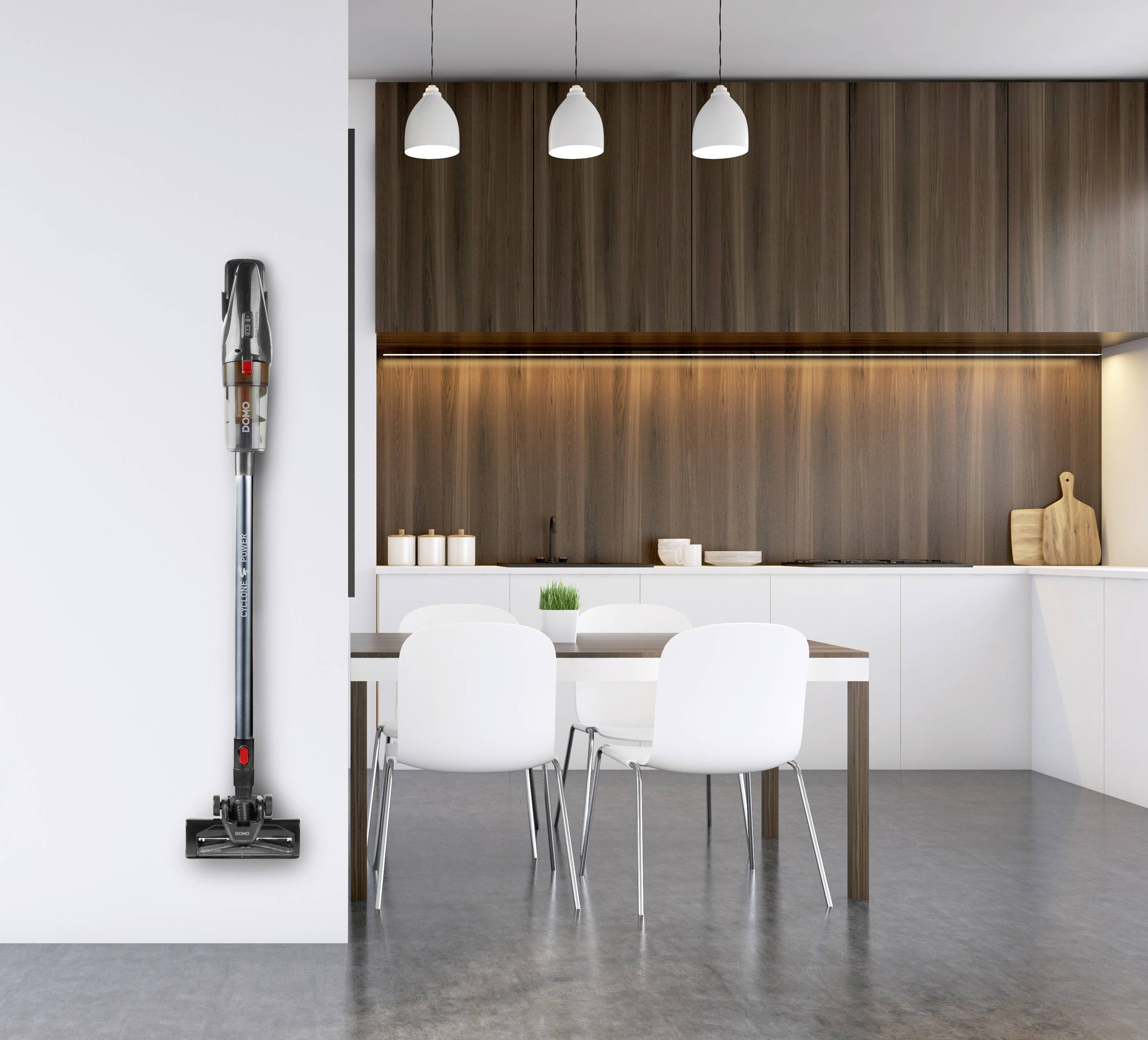 Ein schlanker, kabelloser Staubsauger ist vertikal an einer weißen Wand in einer modernen Küche mit Holzelementen montiert.