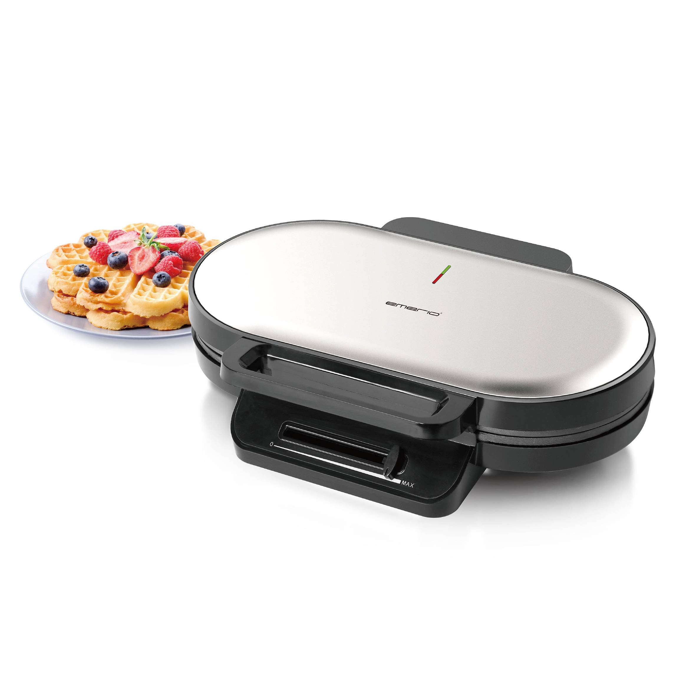 Waffeleisen mit Chromoberfläche, daneben fertig gebackene Waffeln auf einem Teller mit Beeren und Minze garniert.