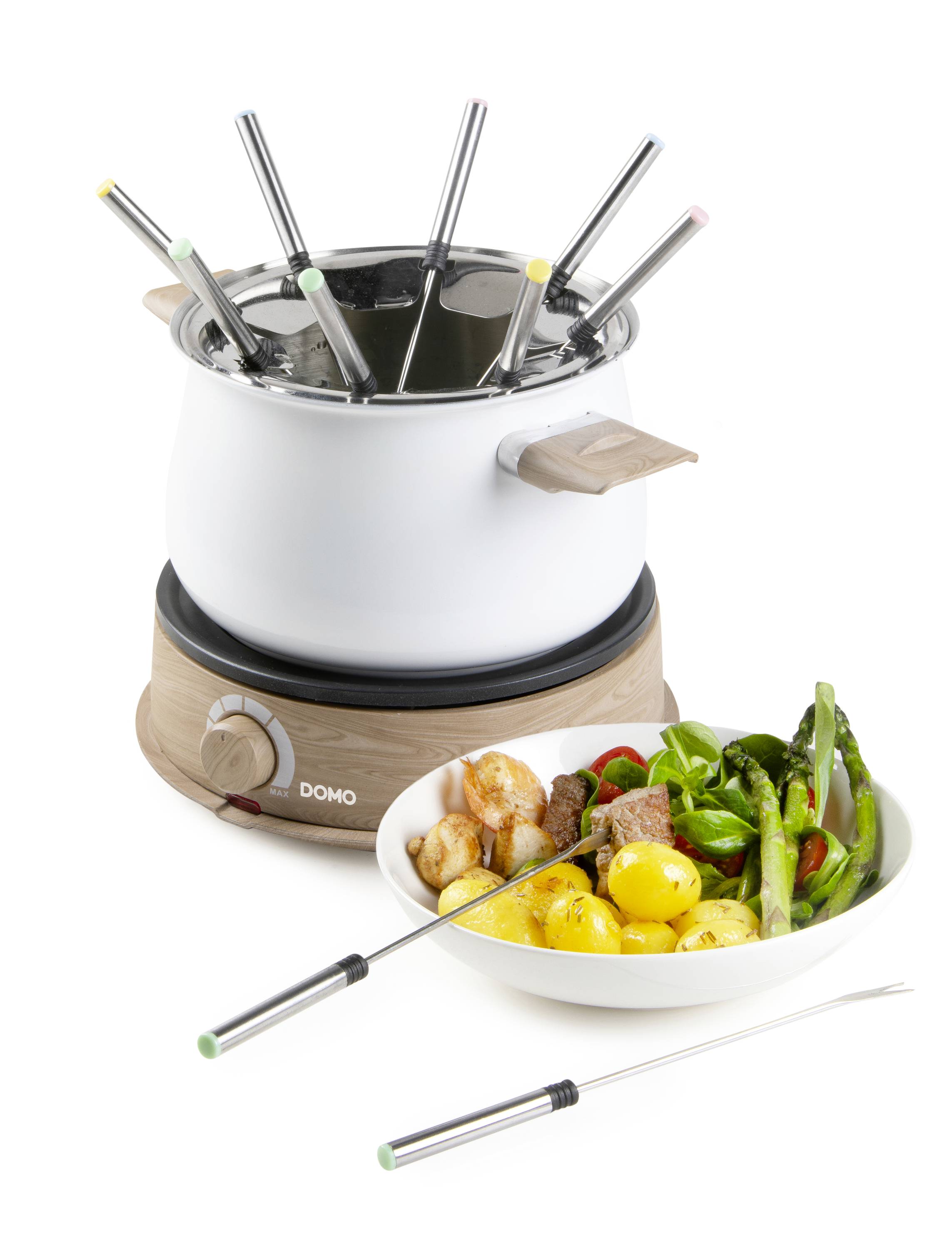 Ein elektrisches Fondue-Set mit mehreren Gabeln, daneben eine Schüssel mit Gemüse, Fleisch und Kartoffeln, bereit zum Eintauchen.
