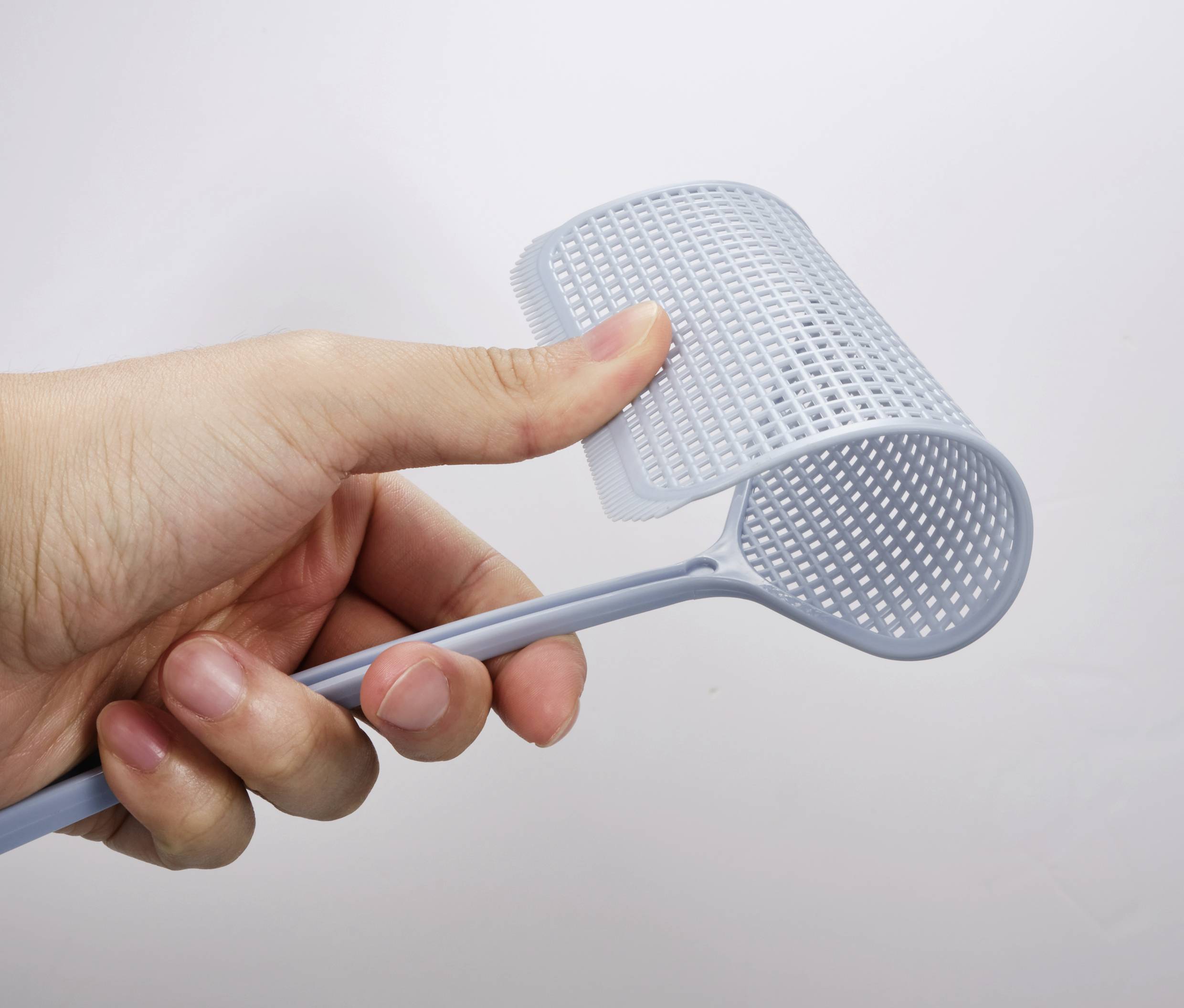 Eine Hand hält einen flexiblen, grauen Griff mit einer gitterartigen Struktur gegen einen weißen Hintergrund.