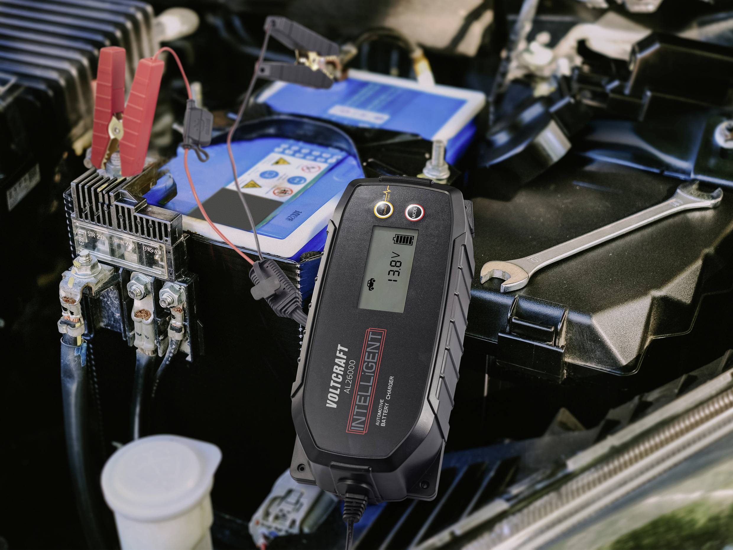 Ein Batterieladegerät ist an eine Autobatterie angeschlossen. Das Display zeigt '13.8V', was den Ladevorgang anzeigt.