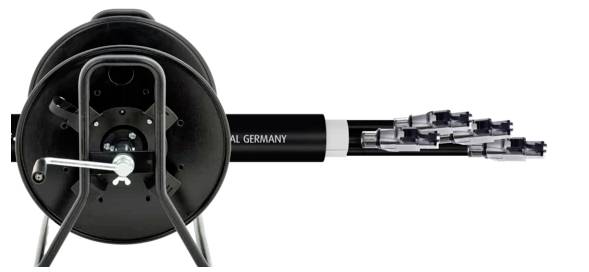 'Kabeltrommel mit abgerolltem Kabel, daran befestigt sind mehrere kleine Stecker. Auf dem Kabel steht 'Germany'. Geeignet für Außenanwendungen.'
