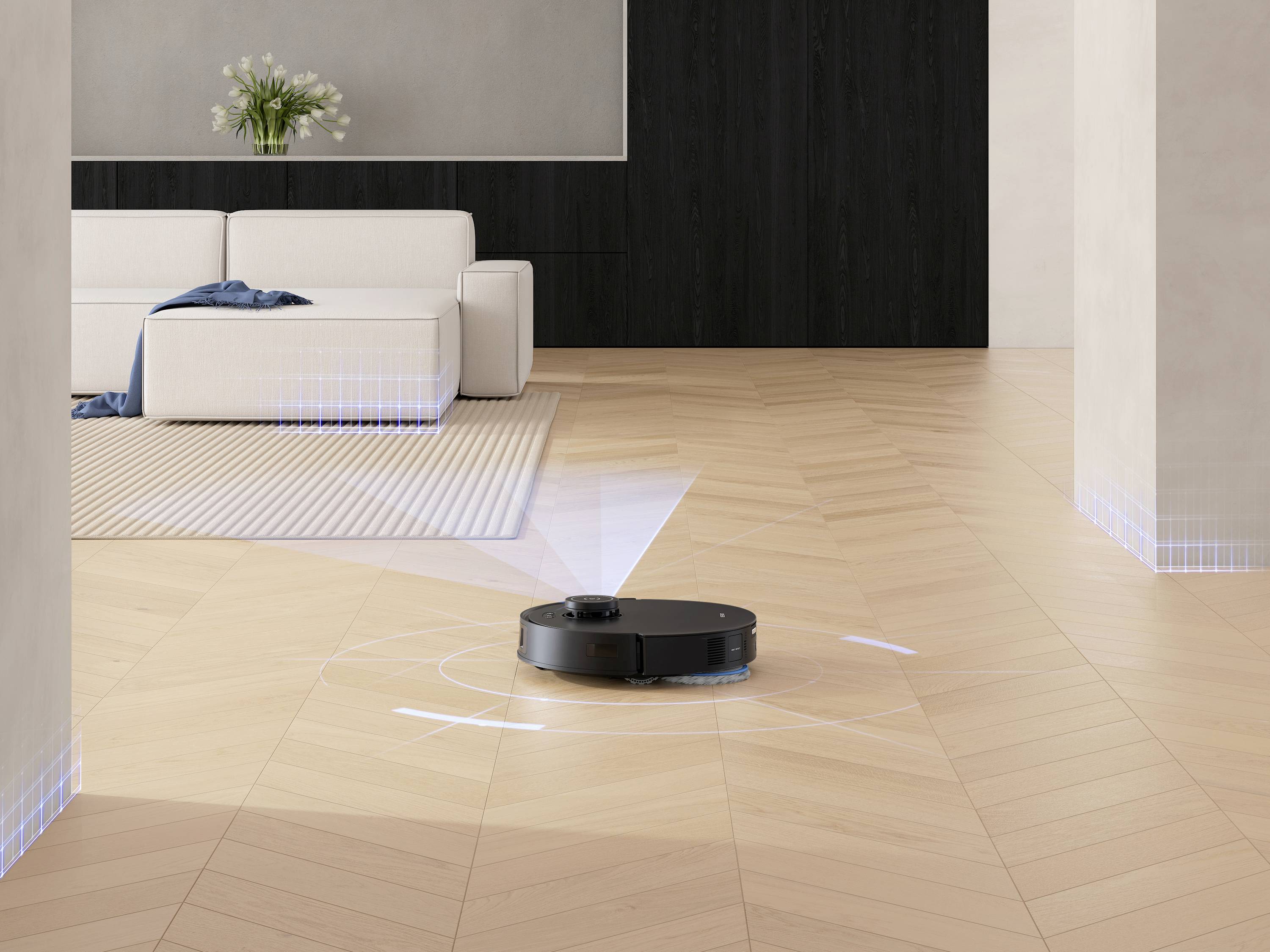 Ein Roboterstaubsauger reinigt den Holzboden in einem modernen Wohnzimmer mit einem weißen Sofa, Pflanzen und einem Teppich.