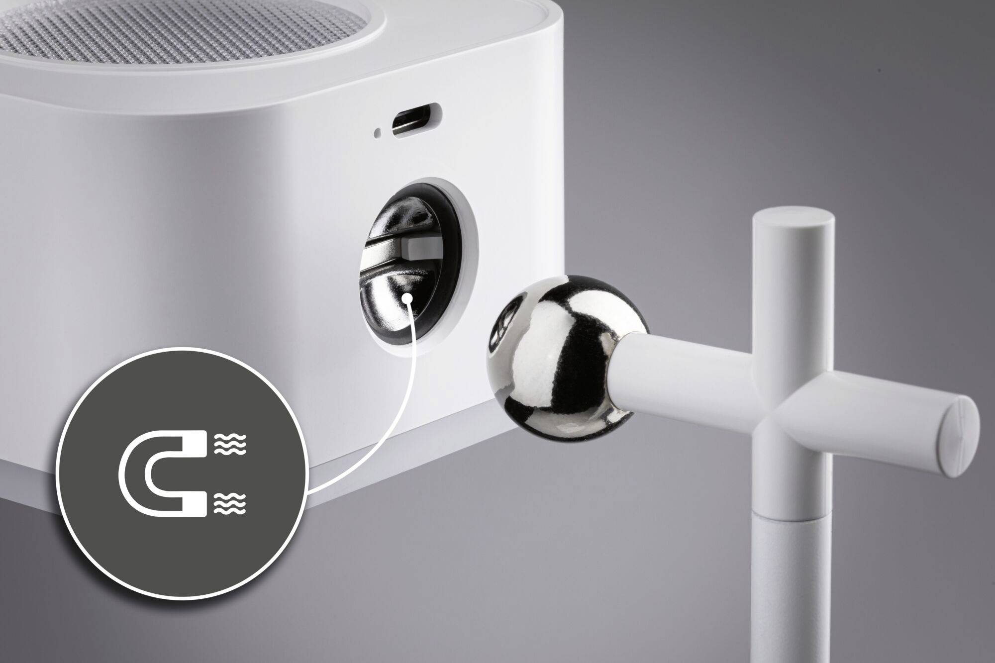 Nahaufnahme eines weißen Geräts mit magnetischem Anschluss. Ein Symbol mit Magneten verweist auf die magnetische Verbindung.