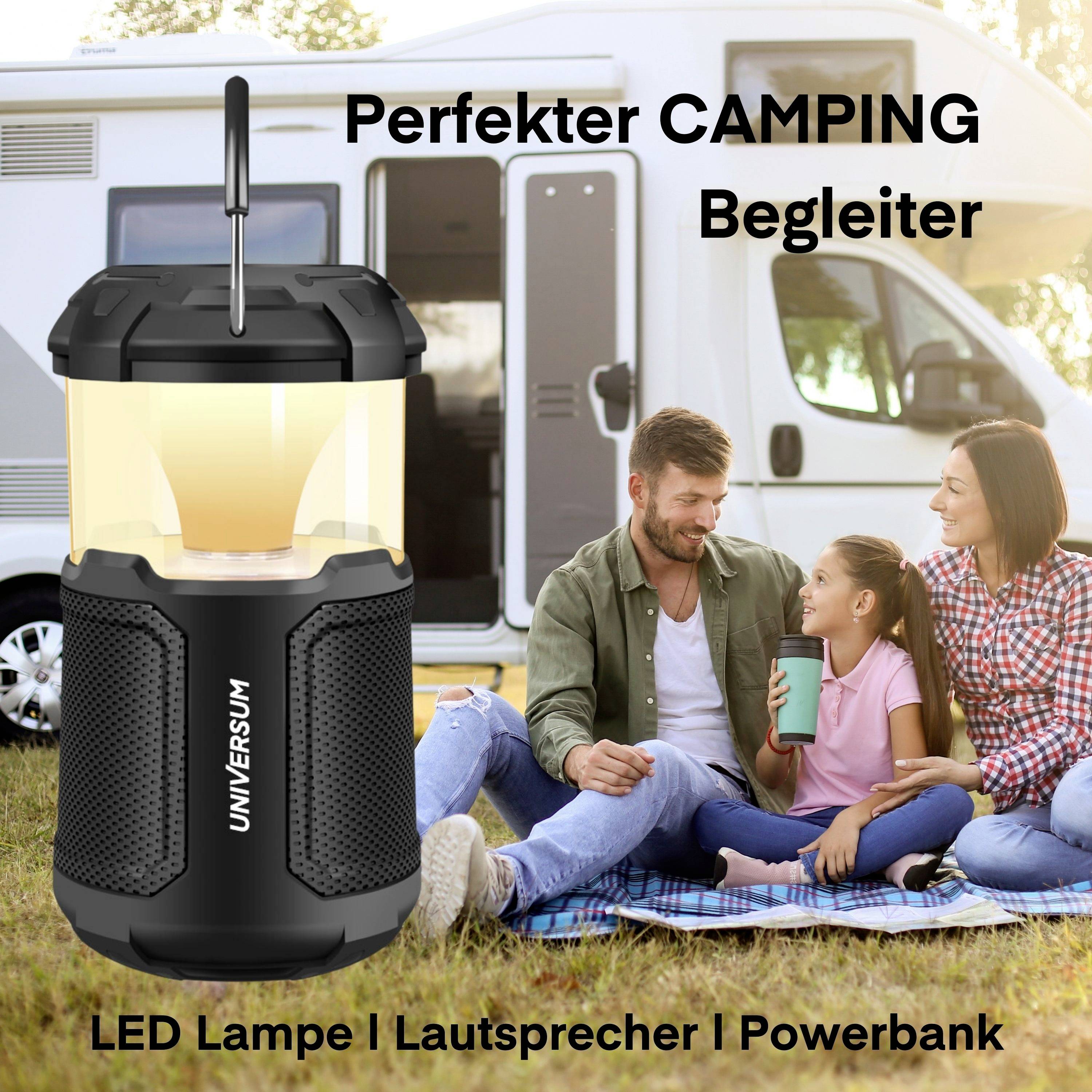 Eine Familie sitzt entspannt im Campingbereich vor einem Wohnmobil. Im Vordergrund steht eine LED-Lampe mit der Aufschrift 'Universum'. Text: 'Perfekter CAMPING Begleiter. LED Lampe | Lautsprecher | Powerbank'.