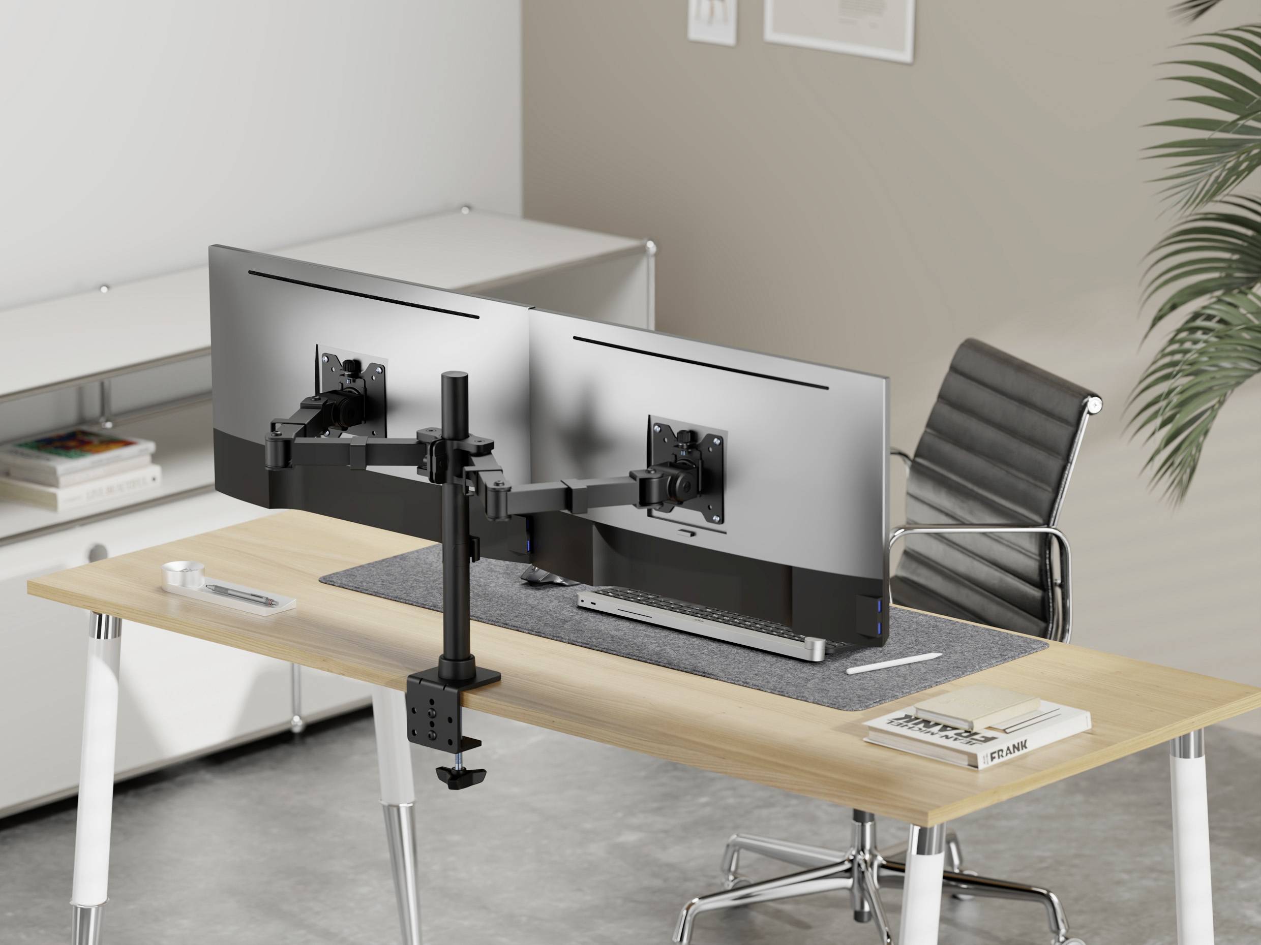 Ein moderner Schreibtisch mit zwei großen Monitoren auf einem Ständer, ergonomischem Stuhl und minimalistischer Einrichtung.