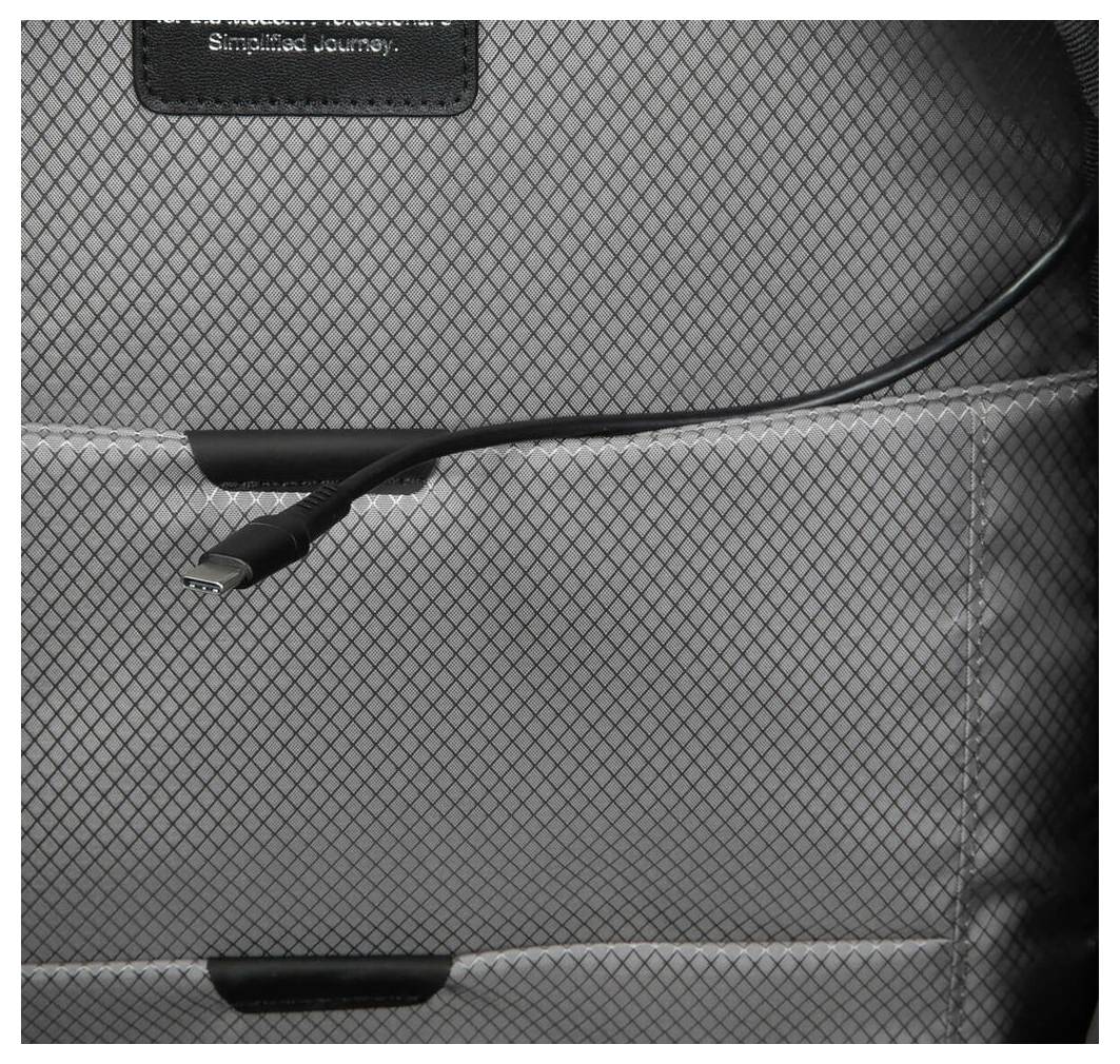 Ein USB-Kabel ist in der Innentasche eines Rucksacks verstaut. Der Innenstoff hat ein graues, kariertes Muster.