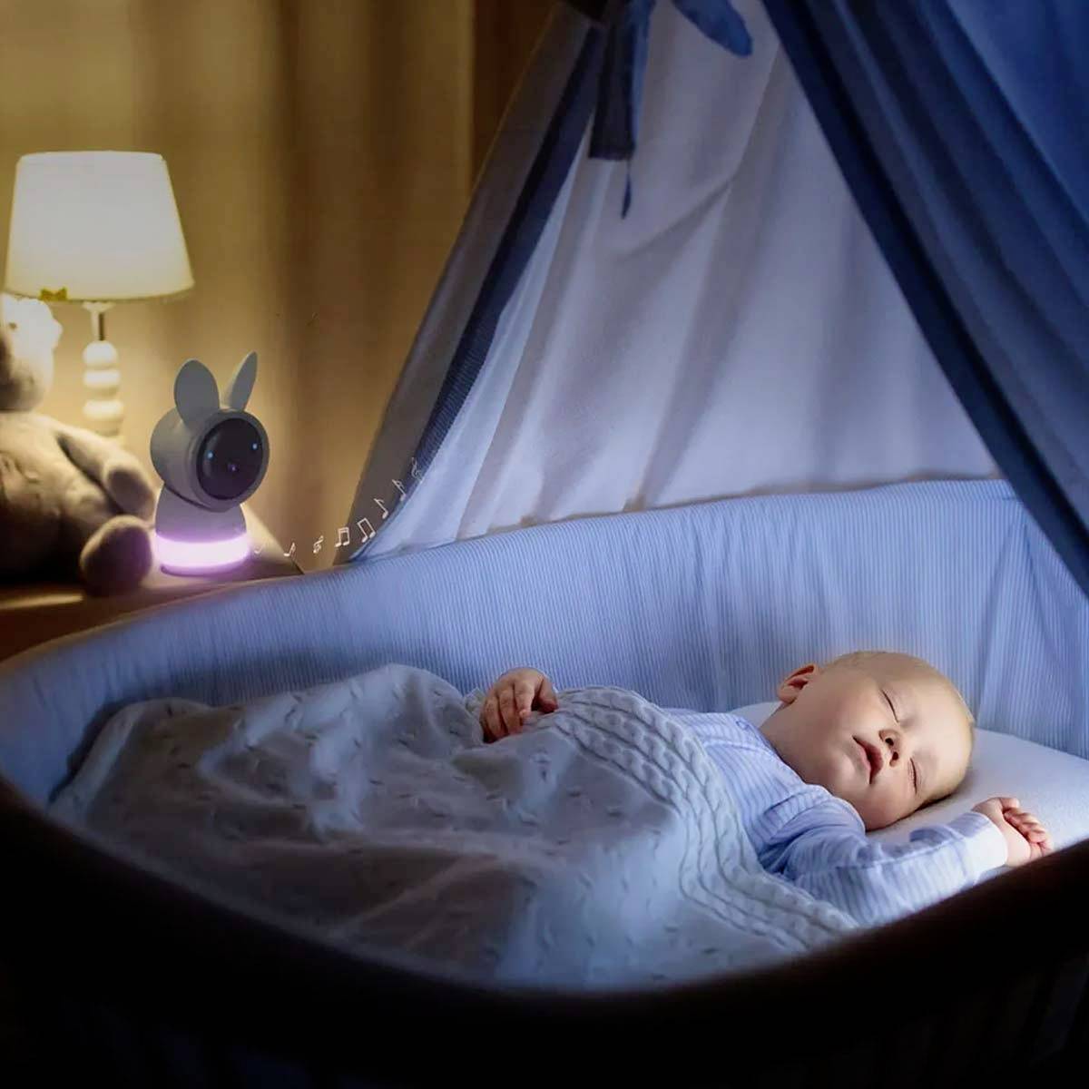 Ein Baby schläft friedlich in einem blauen Bettchen. Daneben steht eine Lampe und ein niedliches Plüschtier.