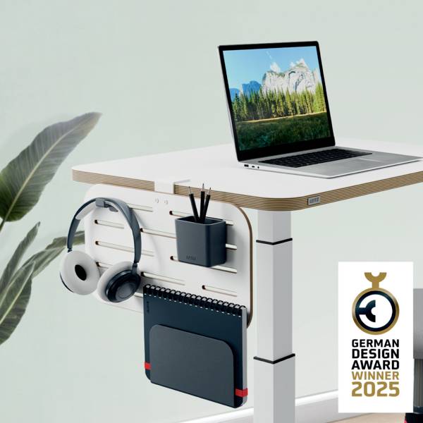 Ein höhenverstellbarer Schreibtisch mit integriertem Zubehör und Laptop, prämiert mit dem 'German Design Award Winner 2023'.