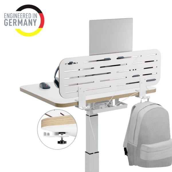 Ein höhenverstellbarer Schreibtisch mit Laptop und grauem Rucksack, links oben das Logo 'Engineered in Germany'.