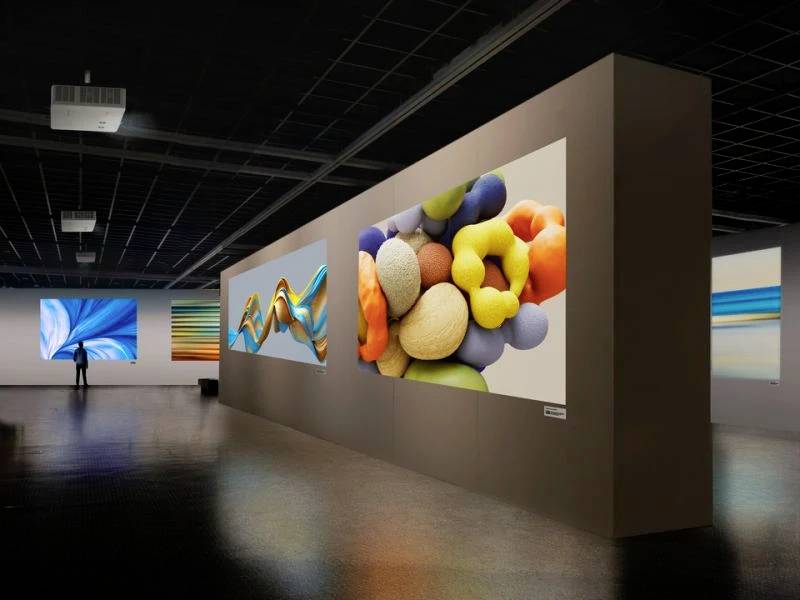 Ein Kunstmuseum mit großformatigen abstrakten Gemälden, die bunte Formen und Wellen zeigen. Ein Besucher betrachtet ein Werk.