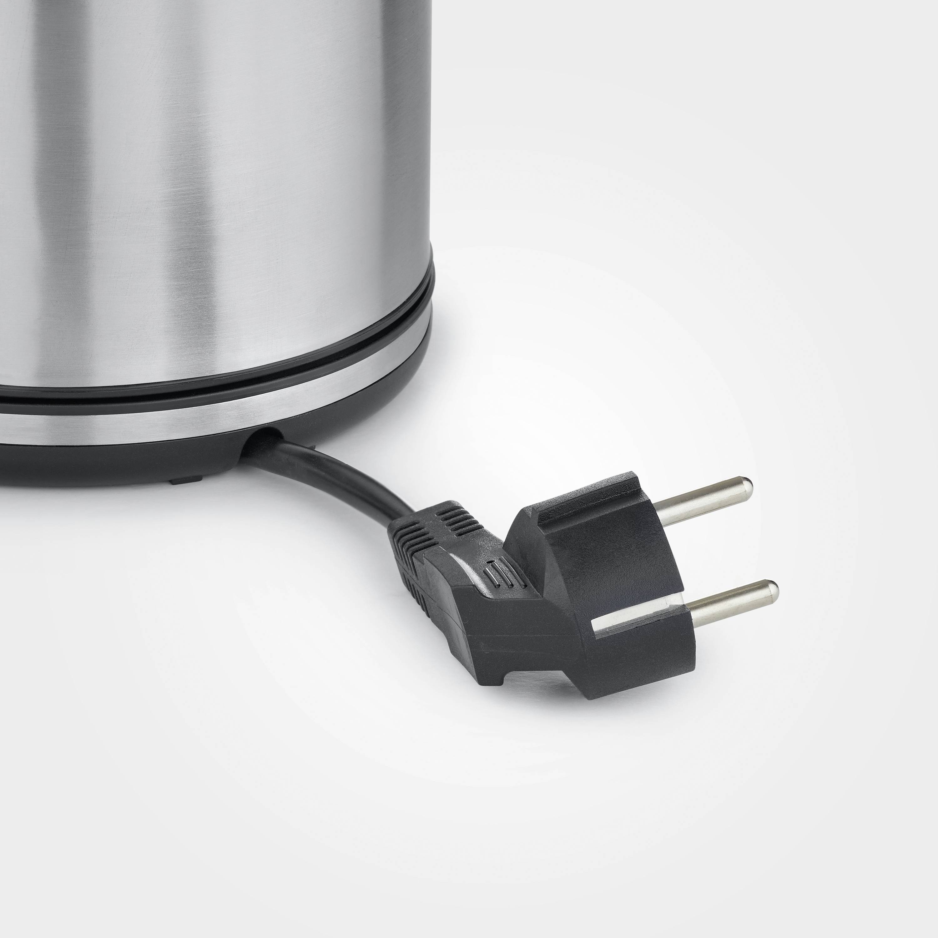 Ein runder, silberner Wasserkocher mit einem schwarzen Netzkabel und Stecker, dargestellt auf einer hellgrauen Oberfläche.