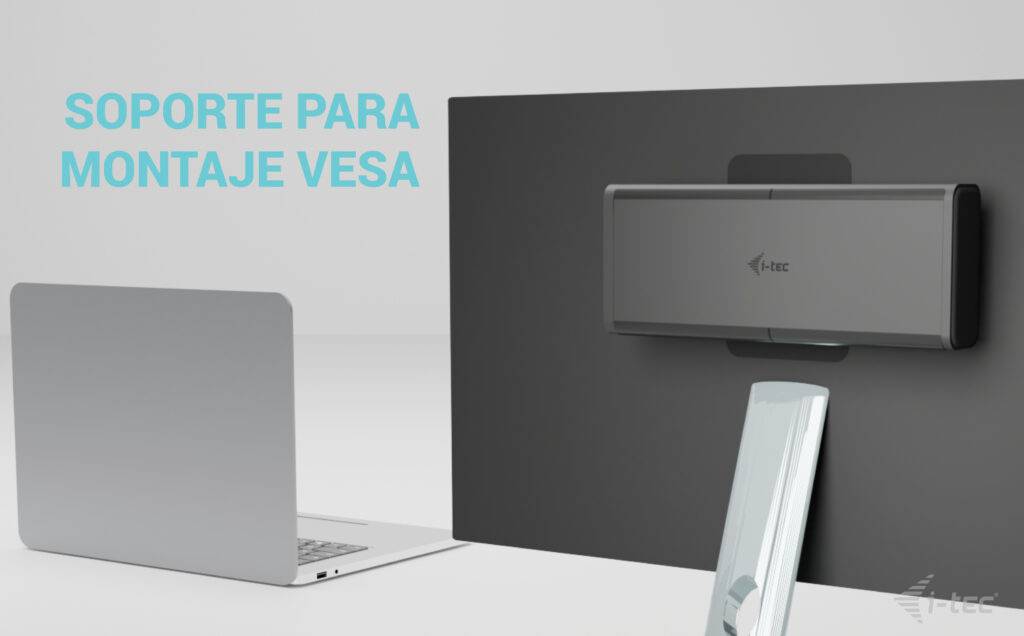 'SOPORTE PARA MONTAJE VESA' auf grauem Hintergrund. Ein schwarzer VESA-Halter ist an einer Wand montiert. Ein Laptop steht daneben.