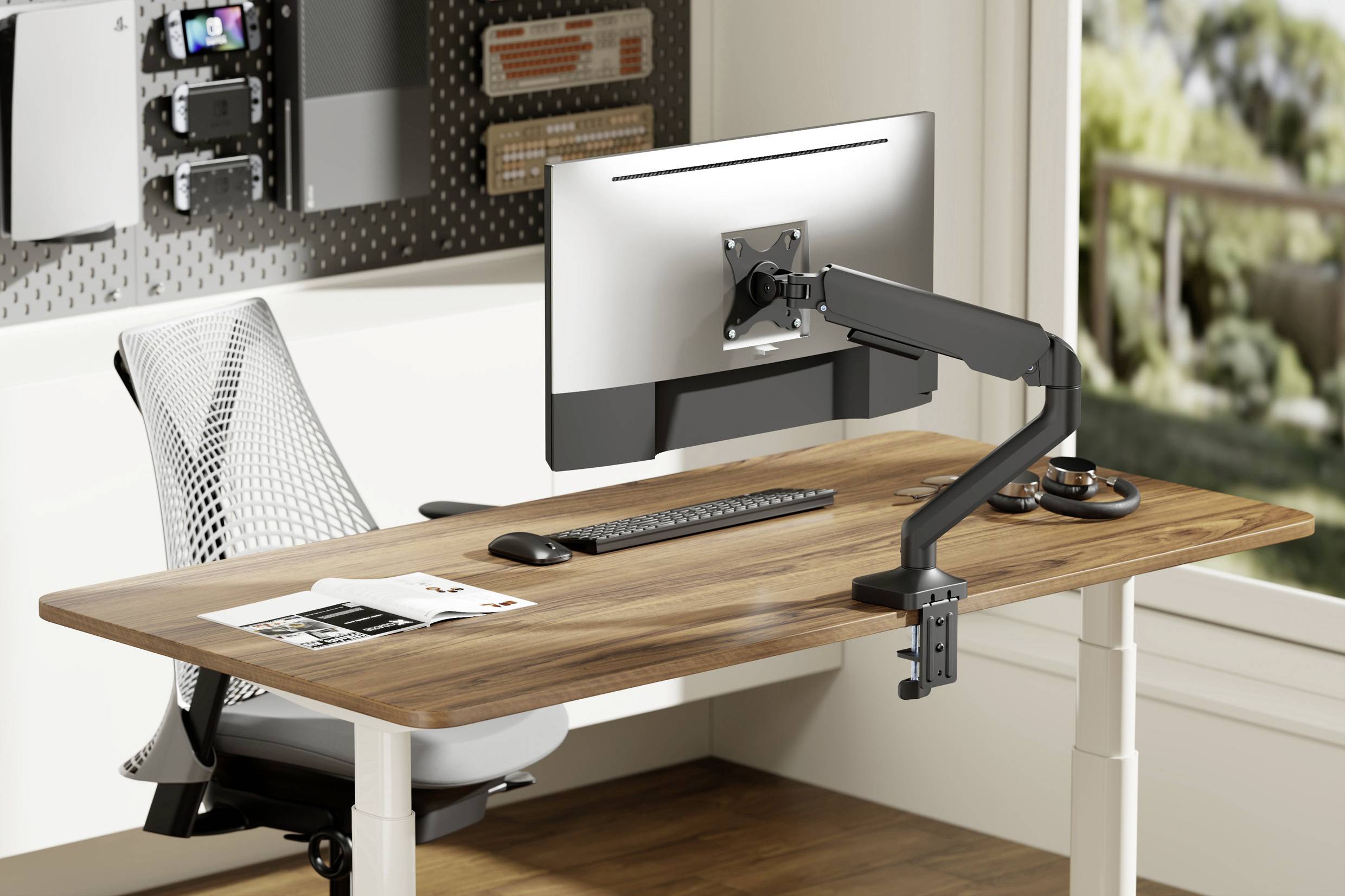 Ein moderner Schreibtisch mit Holzplatte, verstellbarem Monitorarm, Tastatur, Maus und ergonomischem Stuhl vor einem Fenster.