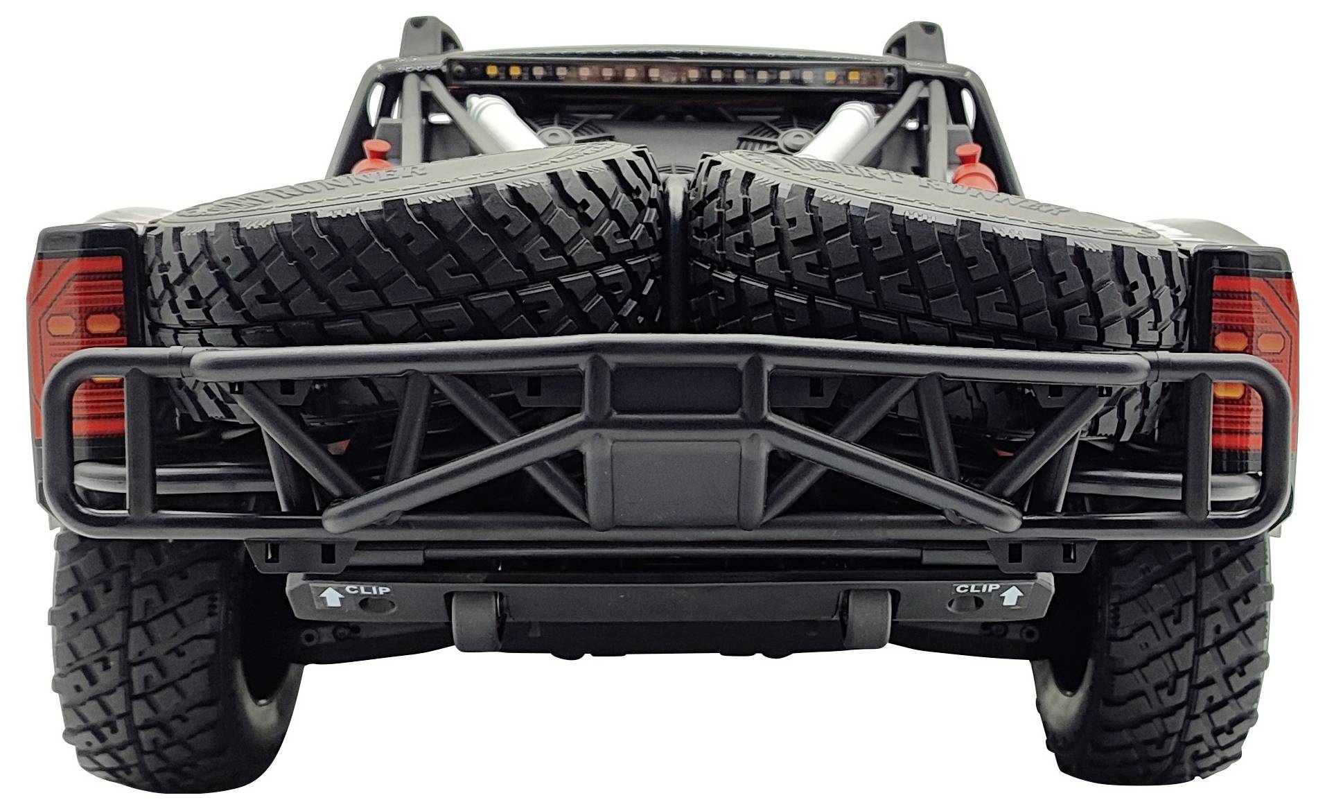 Ein Fahrzeug mit zwei großen Ersatzreifen auf der Ladefläche, aufgenommen von hinten. Die Reifen sind fest gesichert.