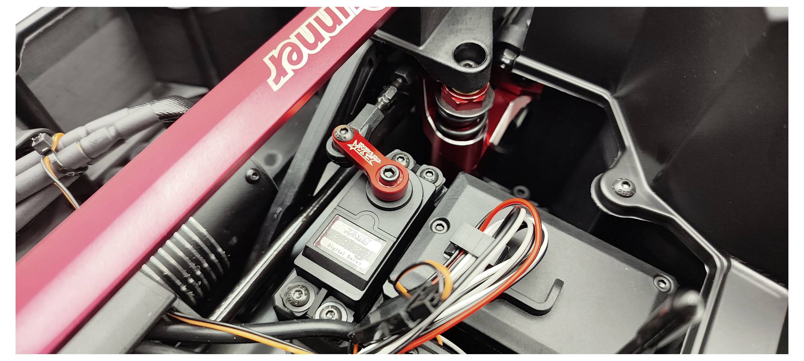 Eine Nahaufnahme eines Elektronik- und Verkabelungssystems innerhalb eines technischen Geräts, mit einem Servo und diversen Anschlüssen.