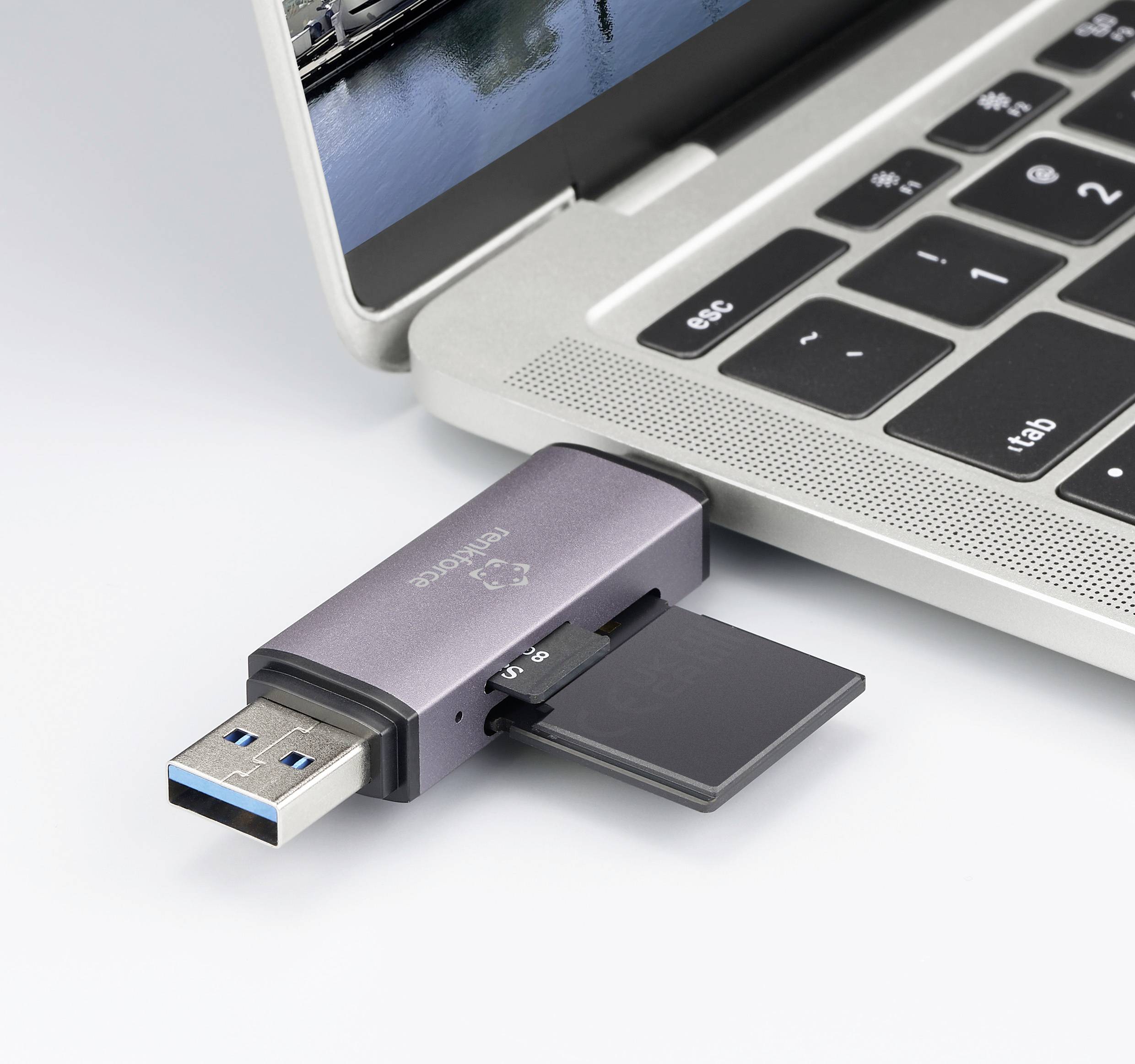 Ein Laptop mit einem USB-Stick im Anschluss. Auf dem Stick steckt eine microSD-Karte. Der Bildschirm zeigt ein unscharfes Bild.