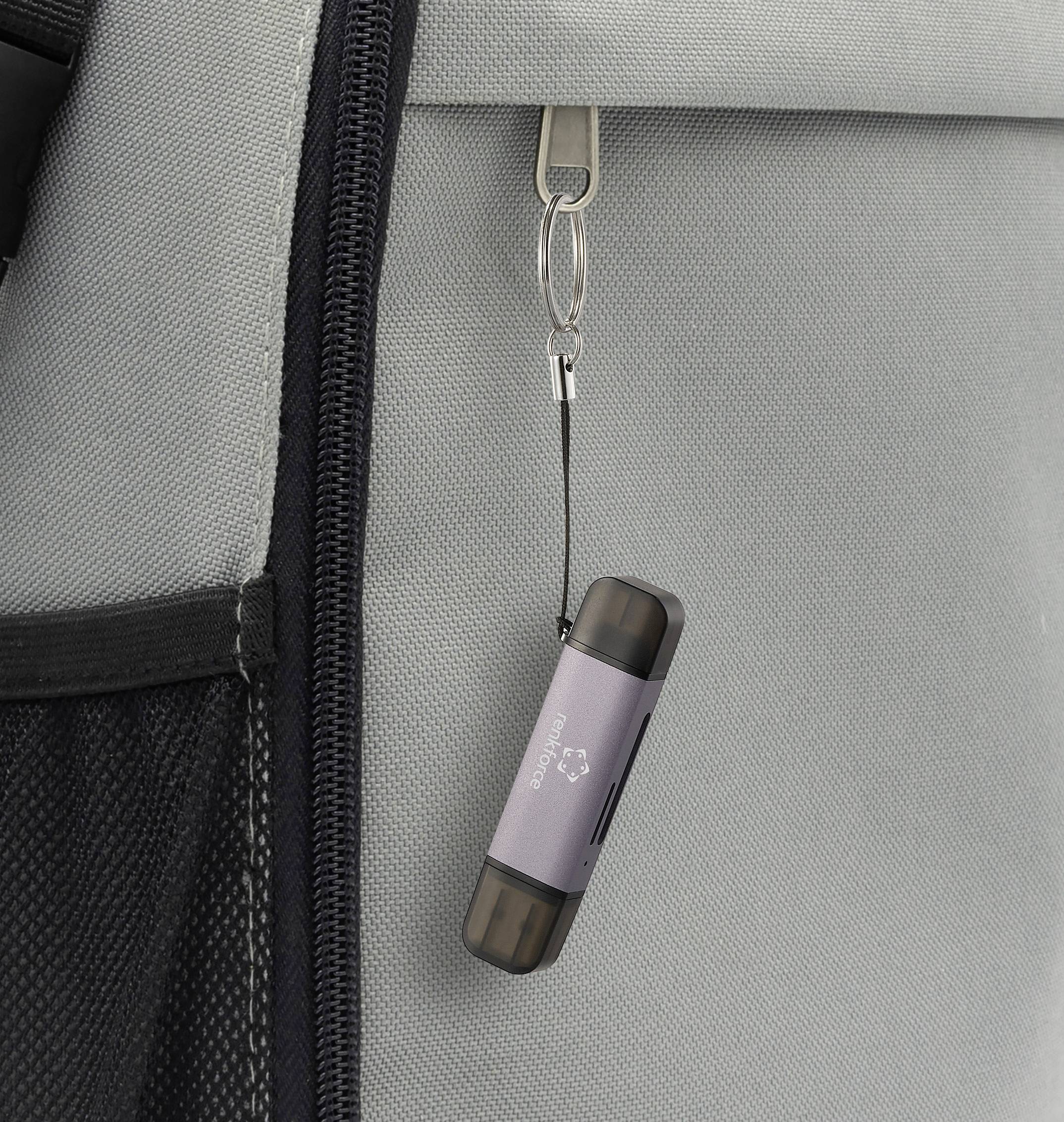 Ein USB-Stick hängt an einem grauen Rucksack.