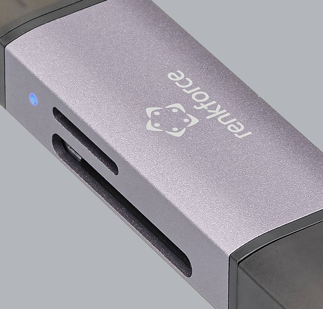 Ein silberner Kartenleser der Marke 'Renkforce' mit USB-Anschluss und einem Schlitz für SD-Karten, auf grauem Hintergrund.