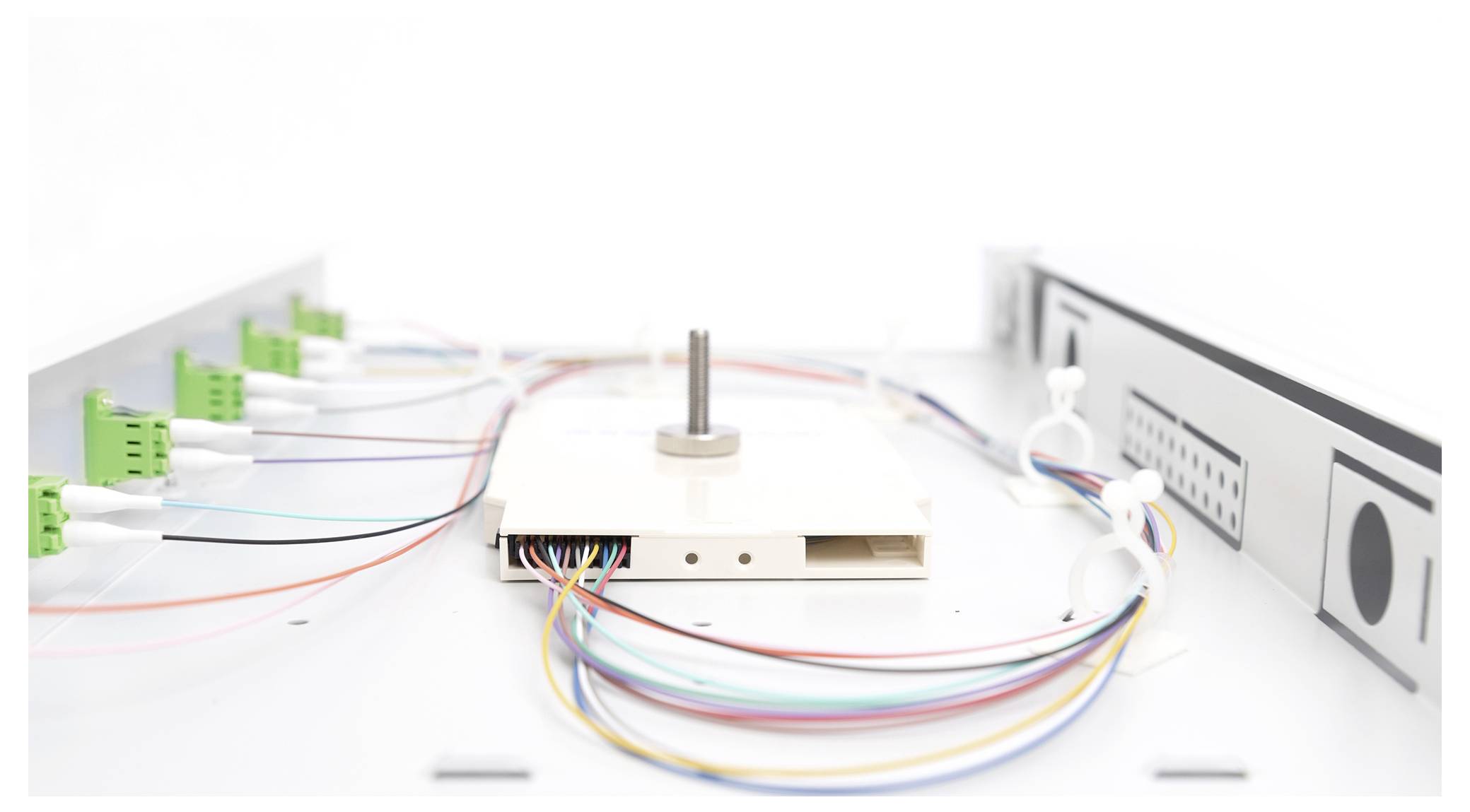 Ein elektrisches Gerät mit mehreren angeschlossenen, unterschiedlich farbigen Kabeln in einer hellen Umgebung.