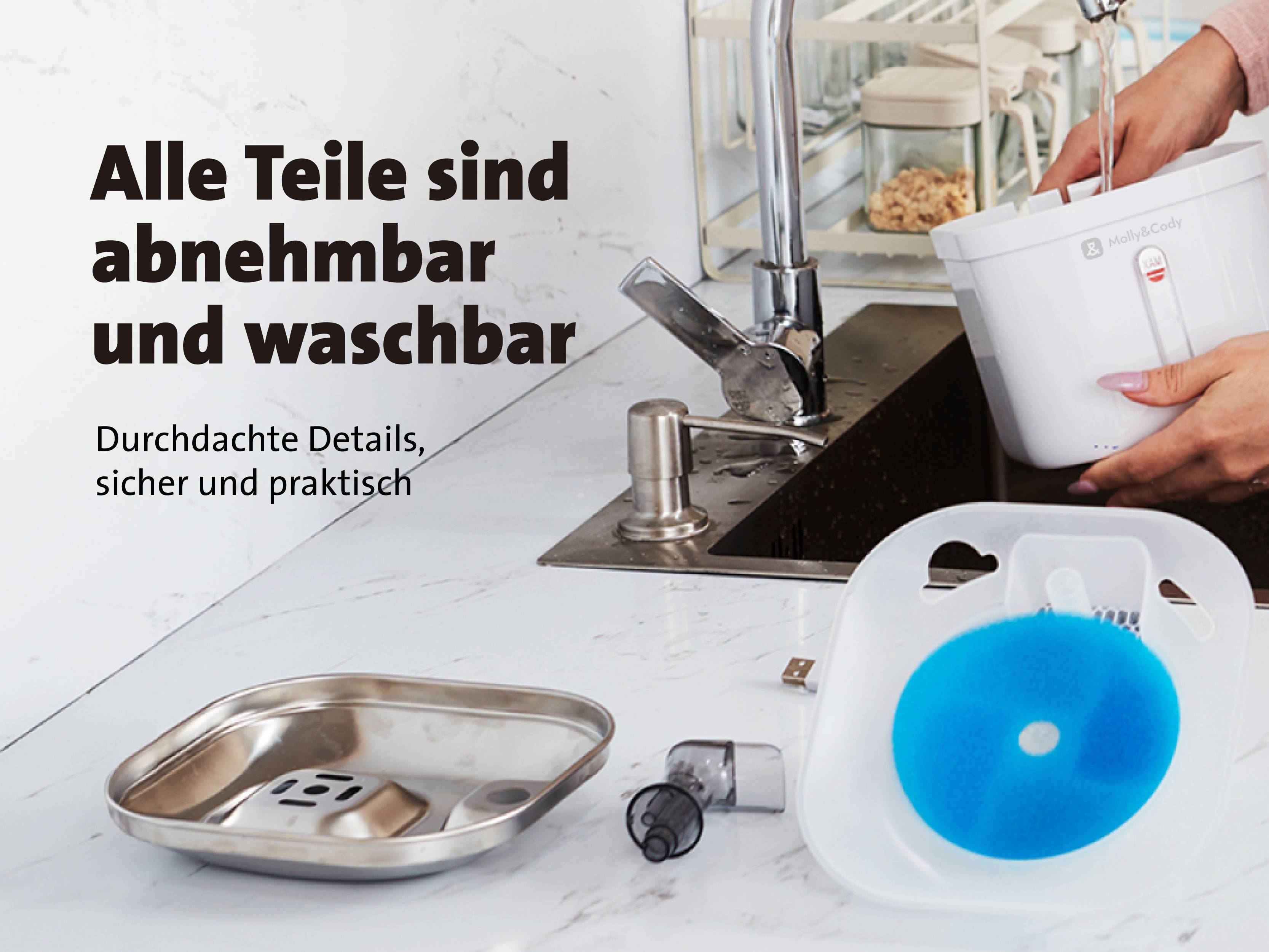 Geräumige Küche mit Waschbecken, daneben ein Abtropfbehälter. Text auf Deutsch: 'Alle Teile sind abnehmbar und waschbar'.