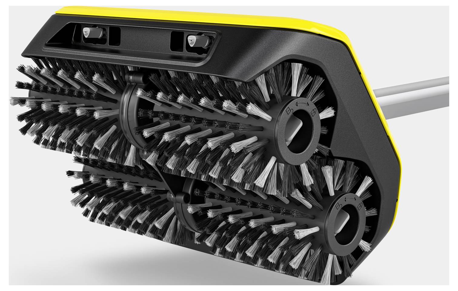 Nahaufnahme einer schwarzen Bürste mit gelben Akzenten, die zwei rotierende Walzen mit Borsten hat.