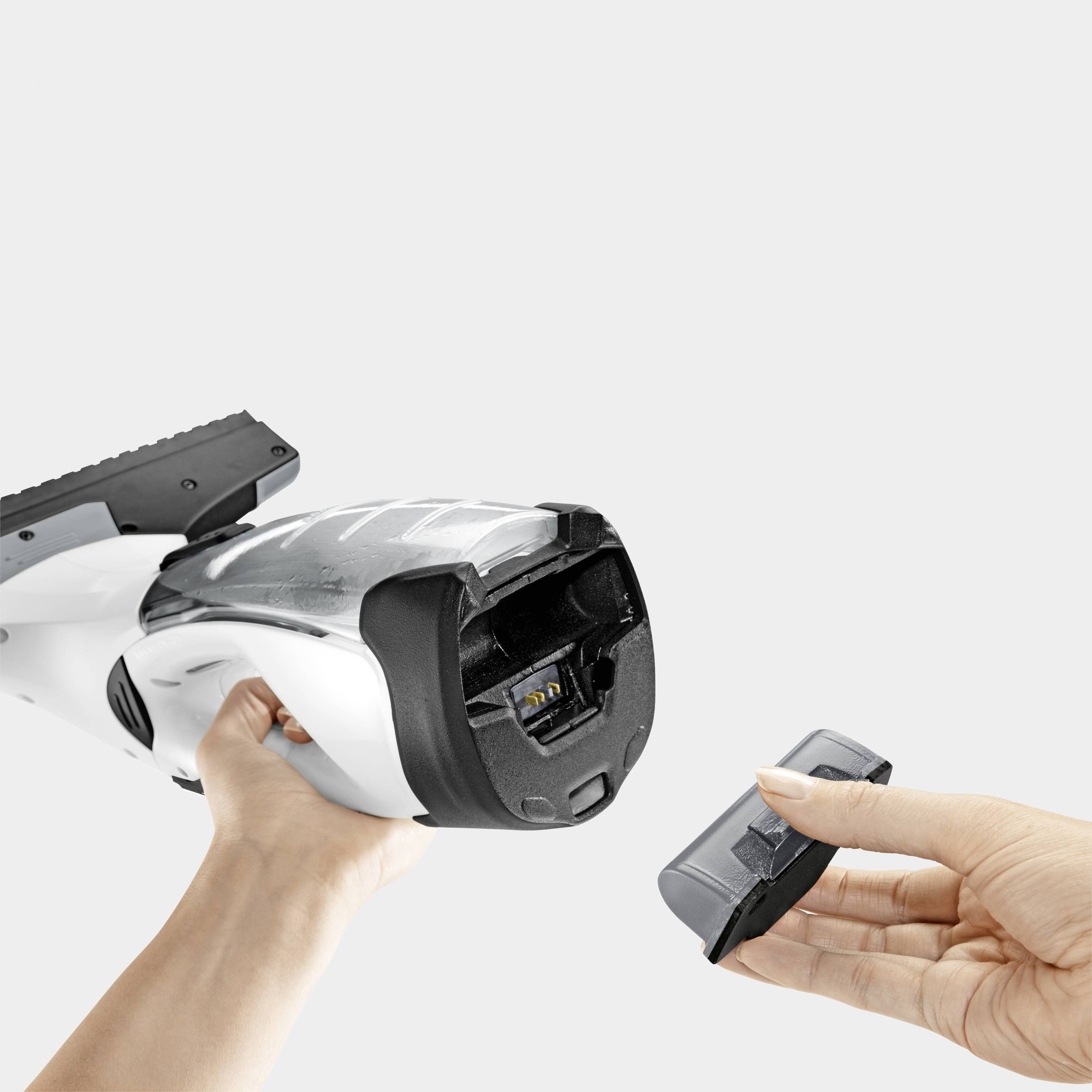 Eine Hand hält einen Fensterreiniger, während eine andere Hand den Akku entfernt. Der Hintergrund ist hellgrau.