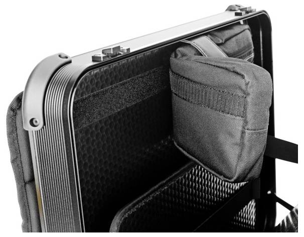 Ein geöffneter Koffer mit schwarzem Innenfutter und einer grauen, befestigten Stofftasche.