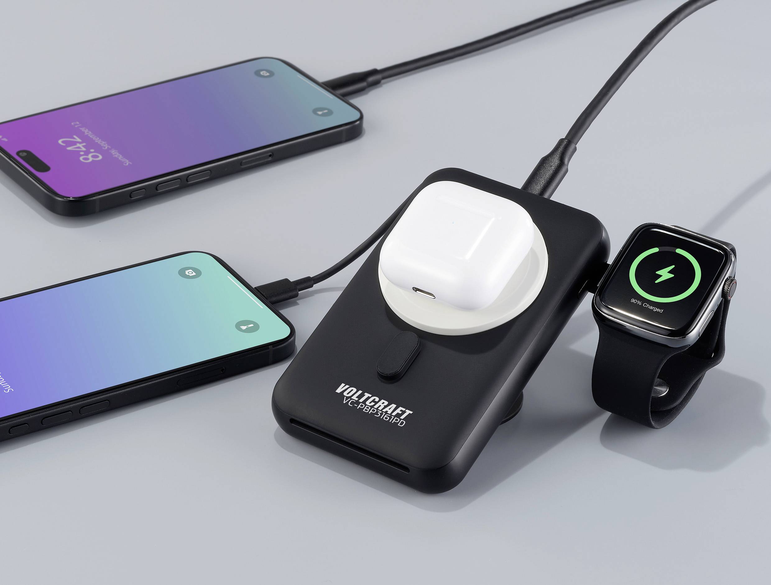 Mehrfach-Ladegerät mit aufgeladenen AirPods, Smartwatch und zwei Smartphones. Ladefortschritt auf den Bildschirmen sichtbar.