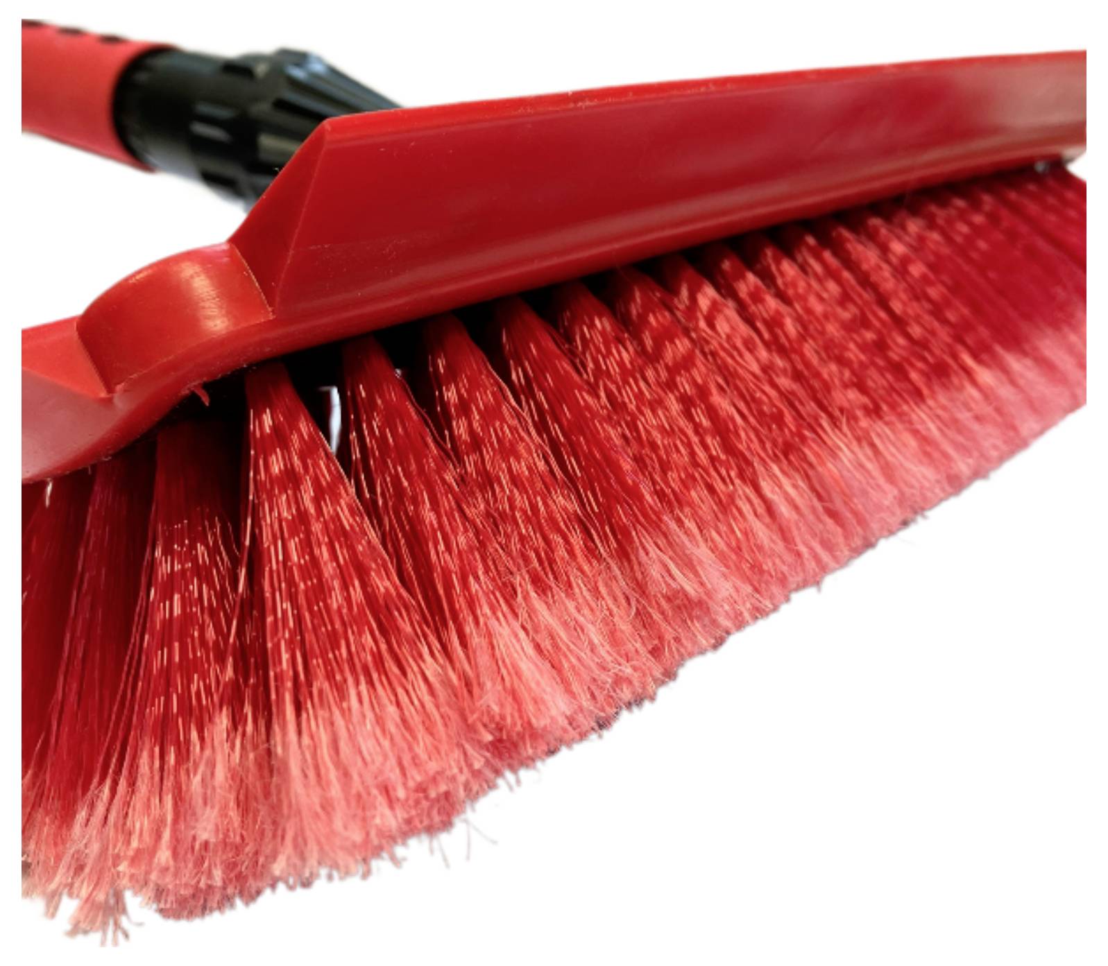 Ein roter Besen mit dichten Borsten, in Nahaufnahme aus einem Winkel gezeigt.