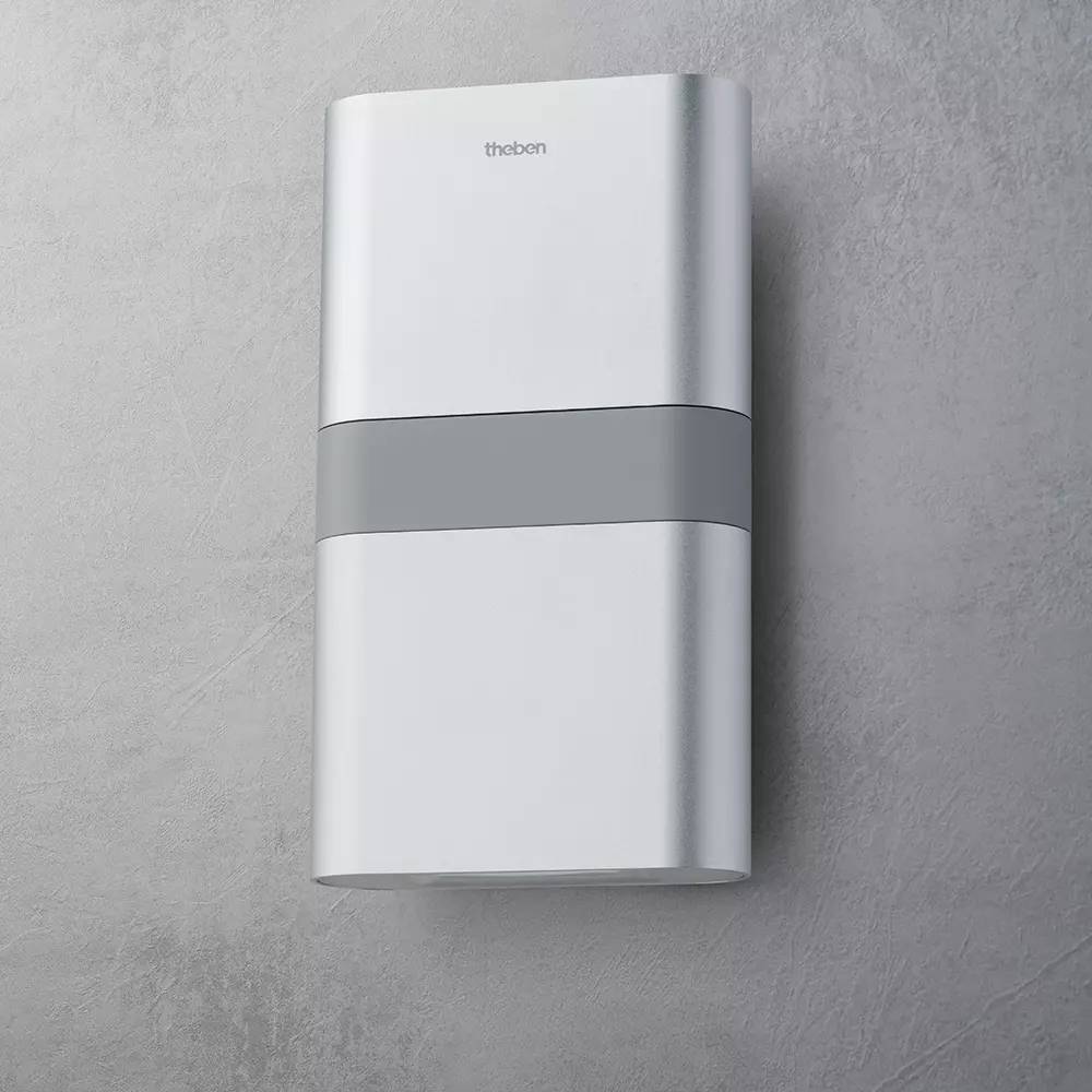 Ein modernes, silbernes Gehäuse an einer grauen Wand. Geeignet für elektrische Installationen oder Steuerungselemente.