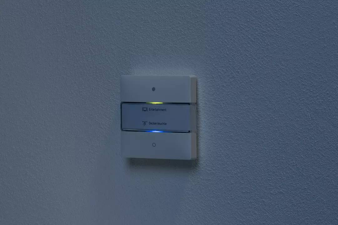 Ein beleuchteter Schalter an einer Wand, mit Beschriftungen für 'Entriegeln' und 'Deaktivieren', zeigt aktuelle Einstellungen.