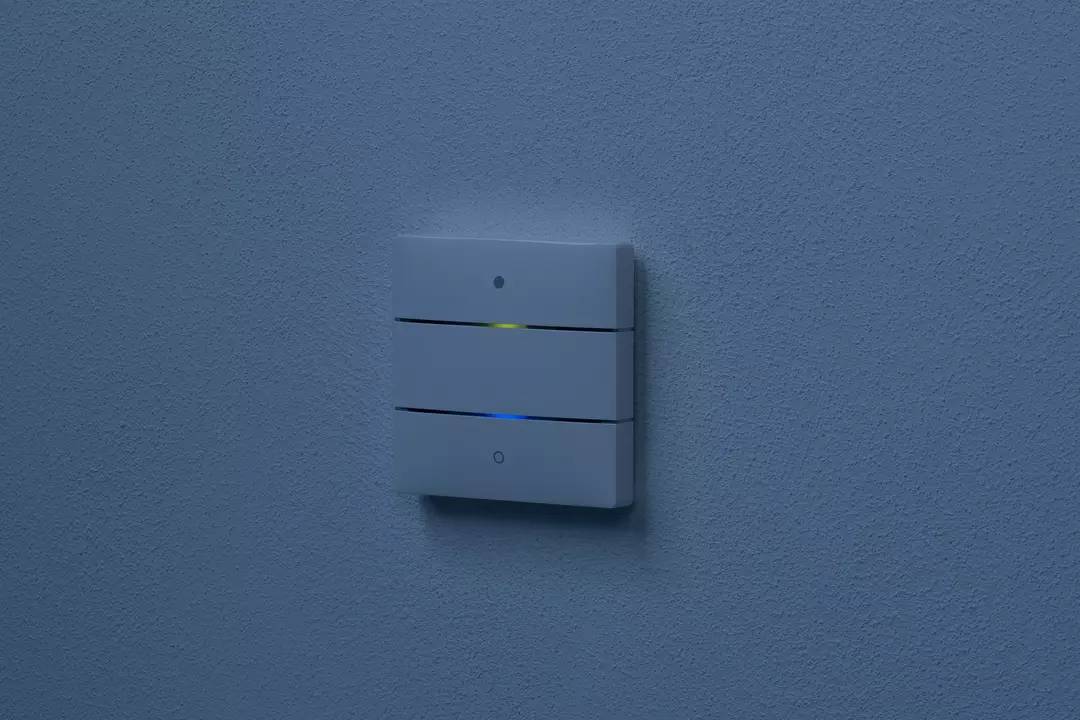 Lichtschalter an einer blauen Wand mit zwei leuchtenden Linien, die blau und gelb leuchten.