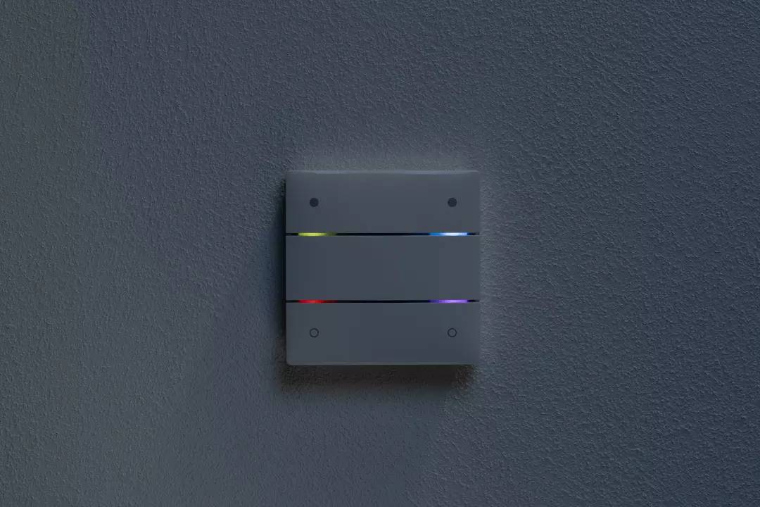 Ein grauer Lichtschalter mit vier horizontalen Streifen, die blau, rot und violett leuchten. Der Schalter befindet sich an einer grauen Wand.
