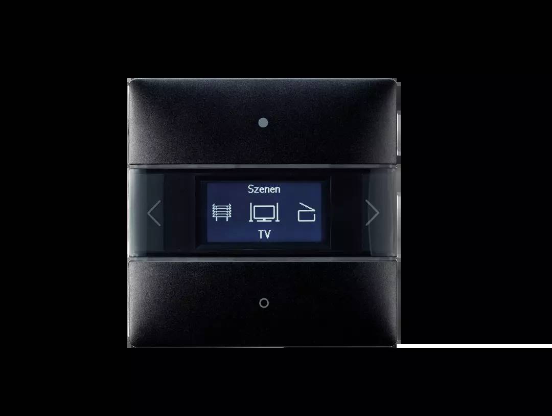 Schwarzes Control-Panel mit Display, zeigt 'Szenen TV' an, umgeben von vier Symbolen: Fernseher, Licht, Musik und Jalousien-Steuerung.