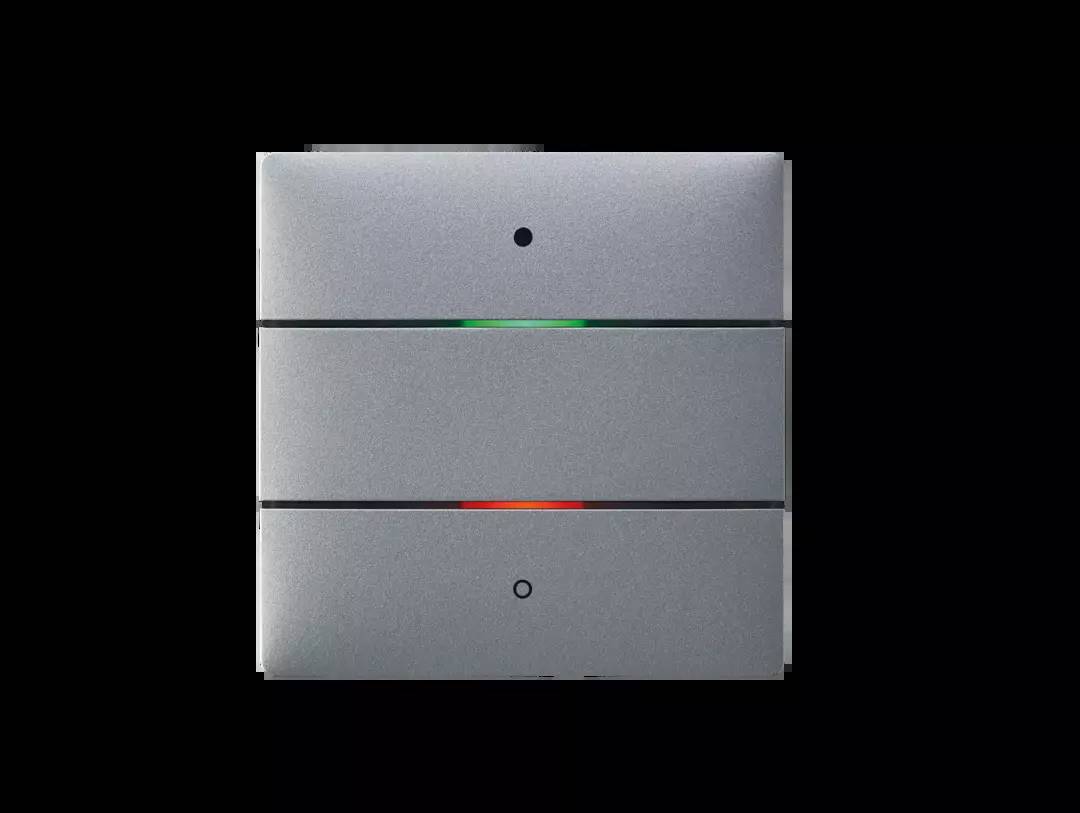 Metallisches Gerät mit drei horizontalen Segmenten; mittleres Segment zeigt oben grünes und unten rotes Licht. Schwarzer Hintergrund.