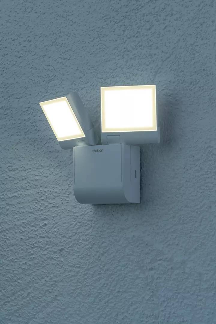 Ein zweifacher Wandstrahler beleuchtet eine Wand. Die beiden quadratischen Leuchten sind hell und richten sich in unterschiedliche Richtungen.