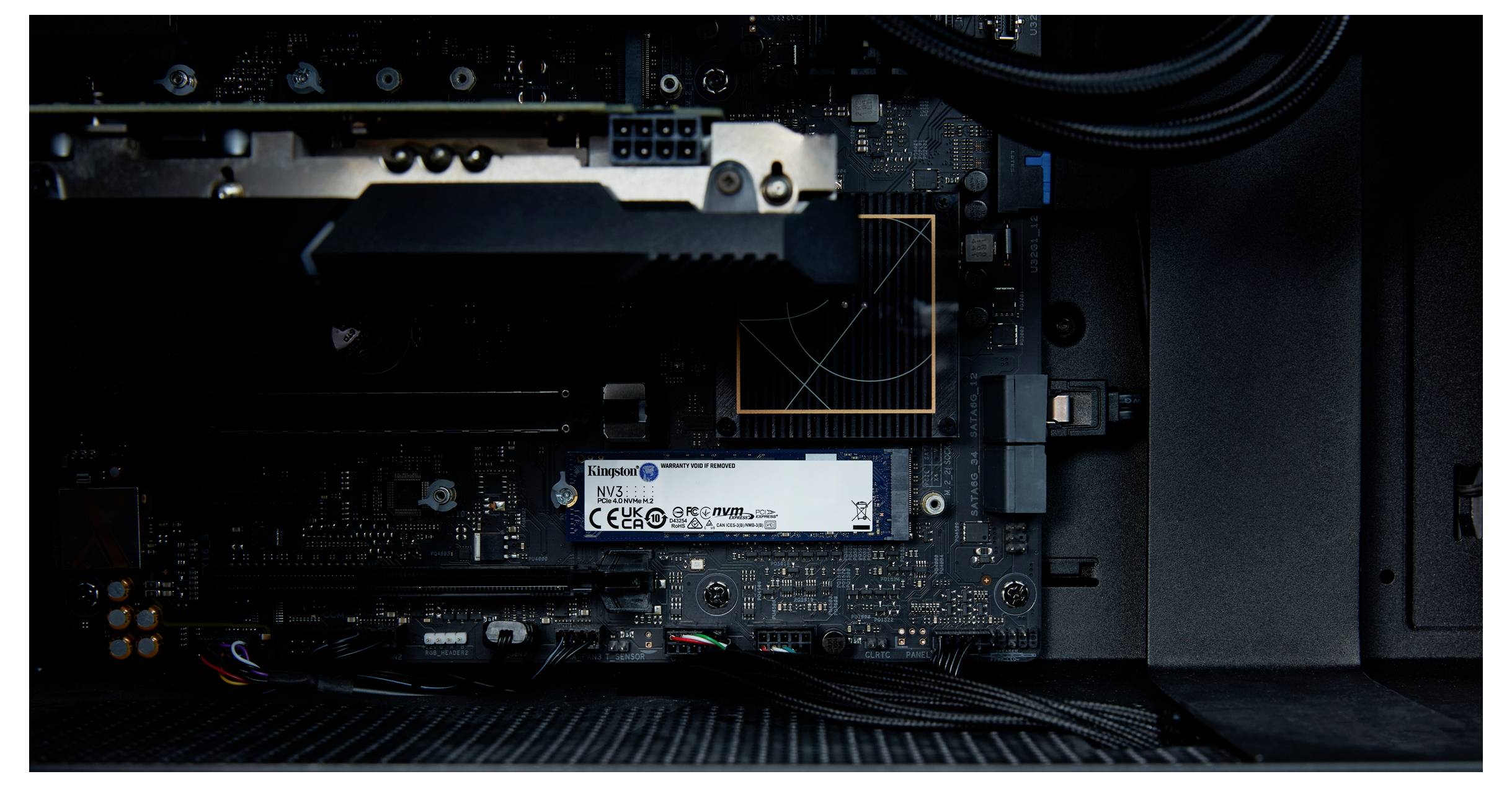 Nahaufnahme eines offenen Computergehäuses mit sichtbaren Komponenten wie einer Grafikkarte und einem SSD-Laufwerk auf dem Motherboard.