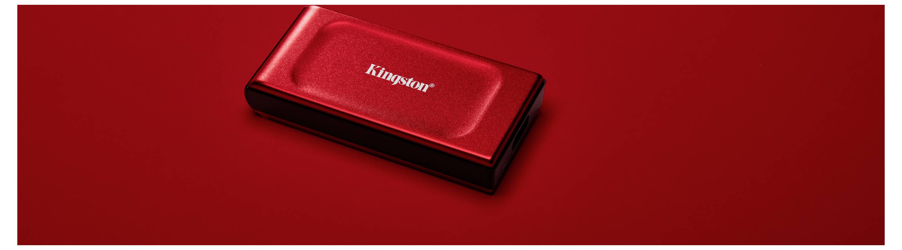 Rote externe Festplatte vor rotem Hintergrund, mit der Aufschrift 'Kingmir' auf dem Gehäuse.