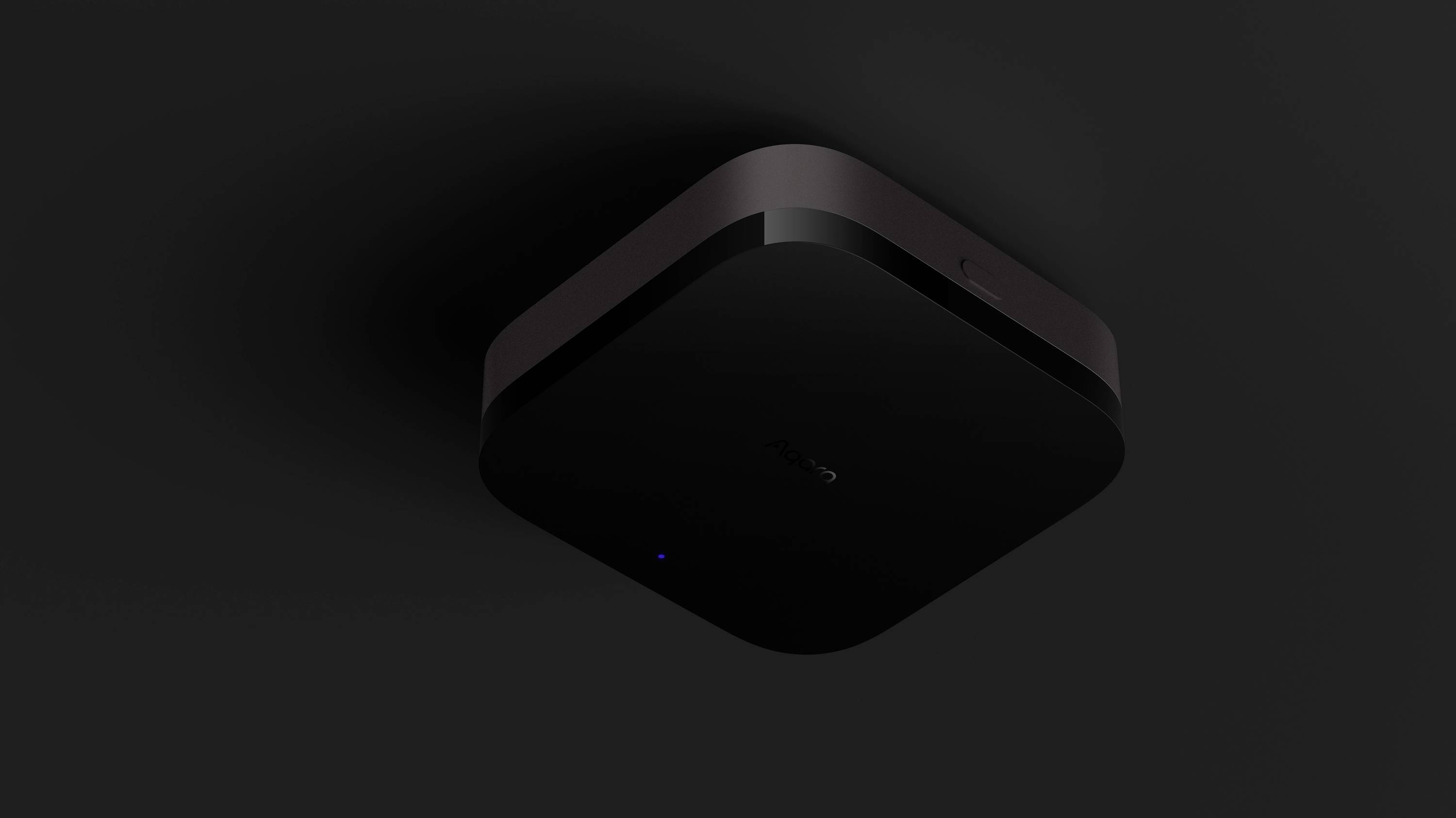 Schwarzer quadratischer Router an dunkler Decke montiert, leuchtet blau.