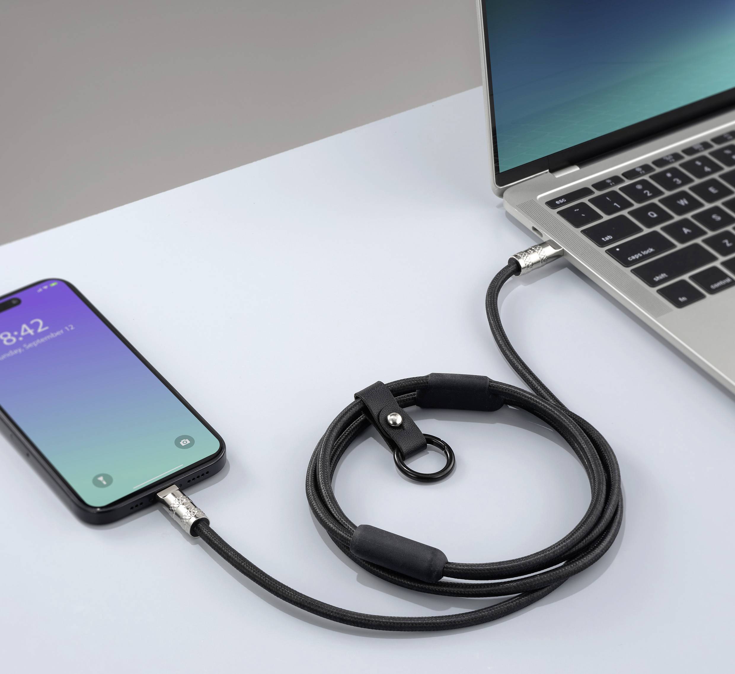 Smartphone verbunden mit Laptop durch ein USB-Kabel. Das Telefon zeigt einen gesperrten Bildschirm.