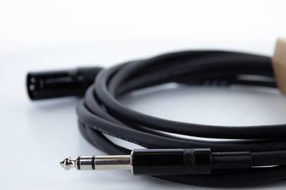 Ein Audio-Klinkenkabel mit einem 6,35-mm-Stecker liegt aufgerollt auf einer Oberfläche.