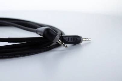 Zwei Audiokabel mit 3,5 mm Klinkensteckern auf einem weißen Hintergrund. Eines der Kabel hat einen abgewinkelten Stecker.