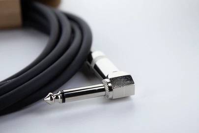 Ein schwarzes Audiokabel mit einem rechtwinkligen Klinkenstecker auf weißem Hintergrund.