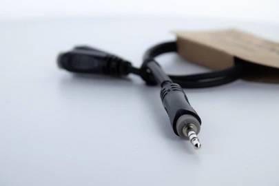 Audio-Kabel mit 3,5-mm-Stecker liegt auf einem Tisch, Verpackung im Hintergrund.