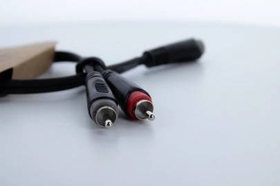 Zwei Cinch-Stecker, einer rot und einer schwarz, liegen nebeneinander auf einer glatten Oberfläche.