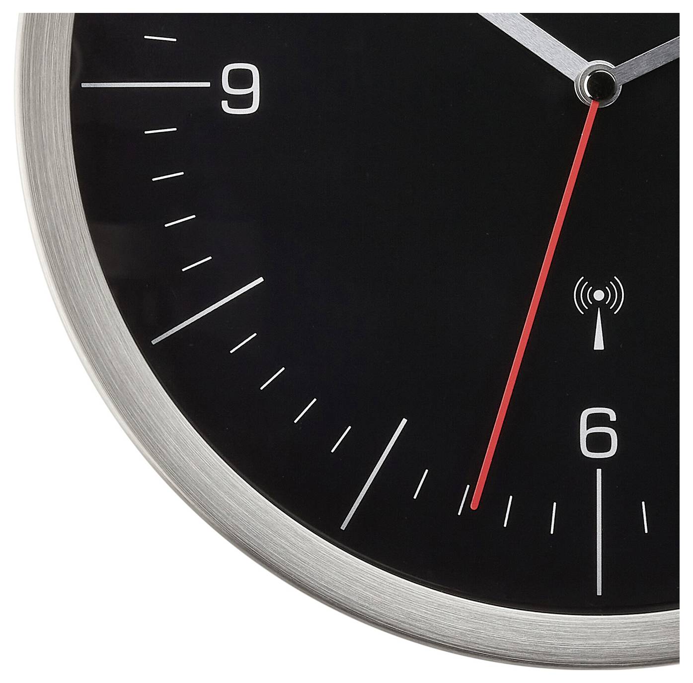 Analoge Uhr in Nahaufnahme, zeigt kurz nach 6 Uhr mit rotem Sekundenzeiger. Schwarzes Zifferblatt mit weißen Strichen und Zahlen.