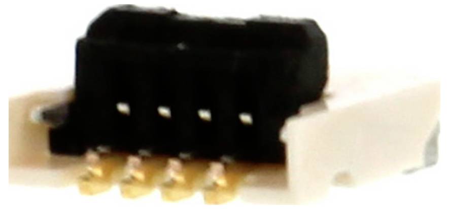 Ein kleiner schwarzer elektronischer Stecker mit vier Metallstiften und einem weißen Kunststoffgehäuse, möglicherweise für Leiterplattenschutzverbindungen.