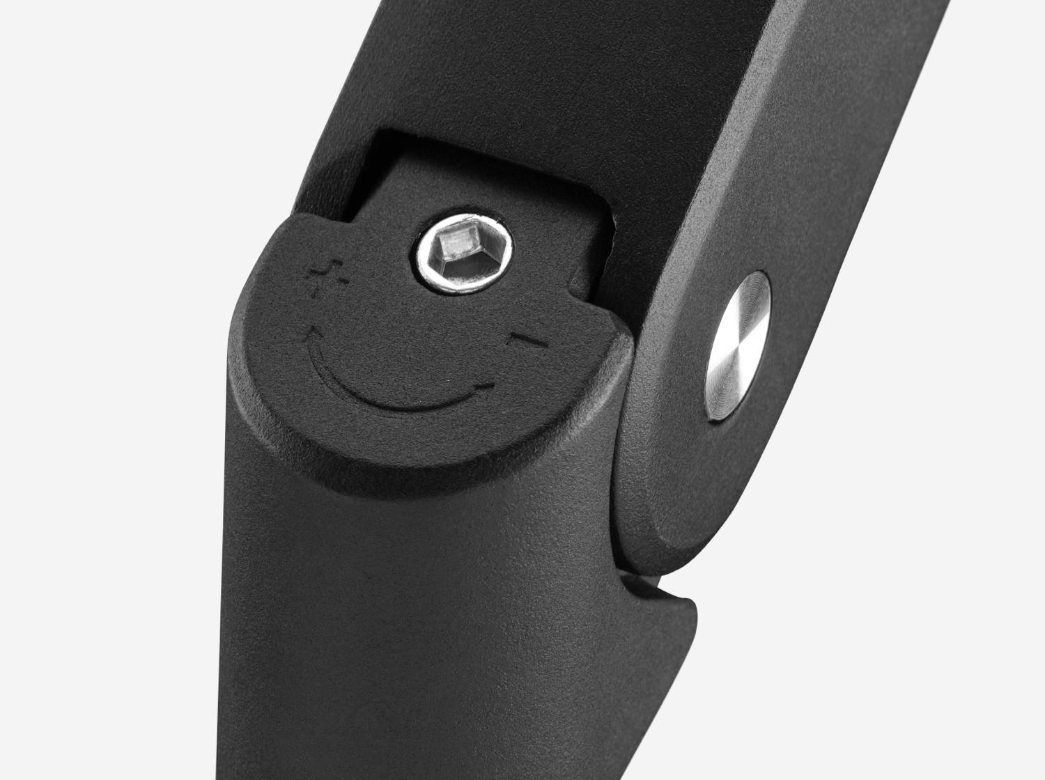 Schraube mit Plus- und Minus-Symbolen auf schwarzem Mechanismus.