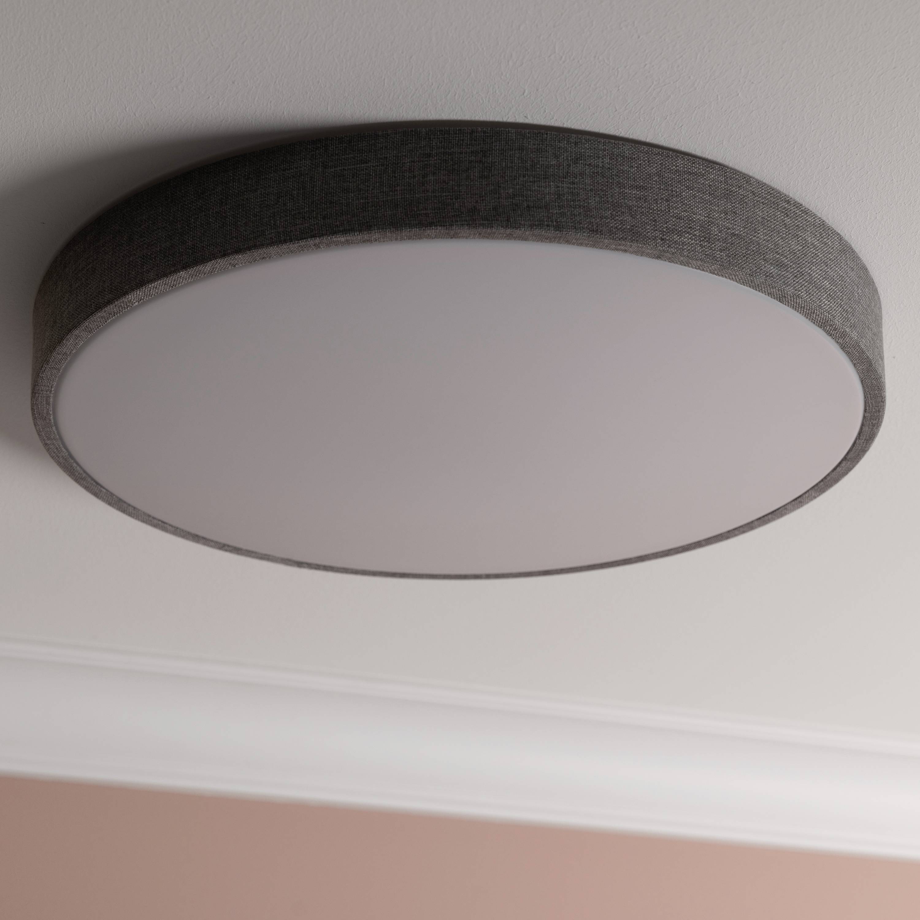 Flache, runde Deckenleuchte mit grauem Rahmen an einer weißen Decke. Beleuchtet gleichmäßig, passt zu moderner Einrichtung.